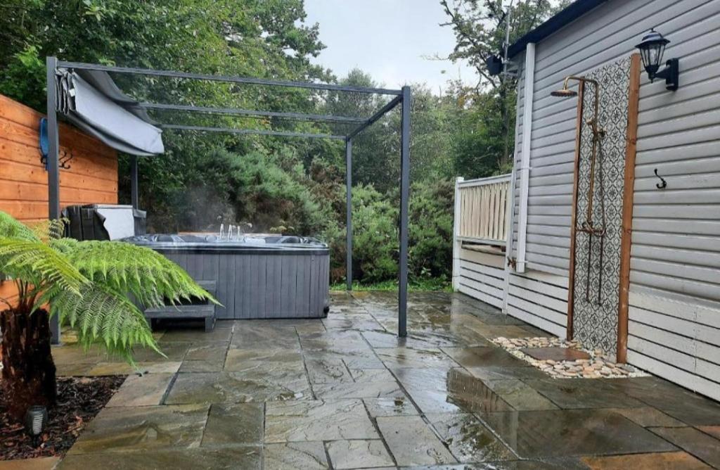 a patio with a hot tub next to a building at The Treehouse Northumberland in Swarland