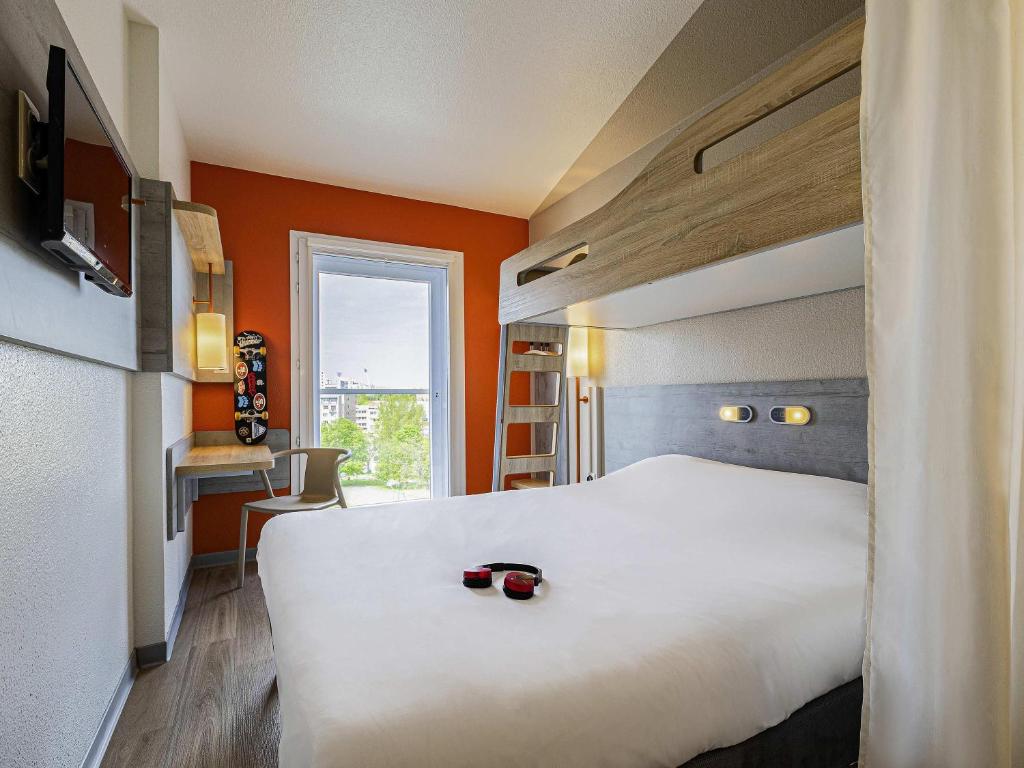 a hotel room with a large white bed and a window at ibis budget Paris Porte d'Italie Ouest in Le Kremlin-Bicêtre
