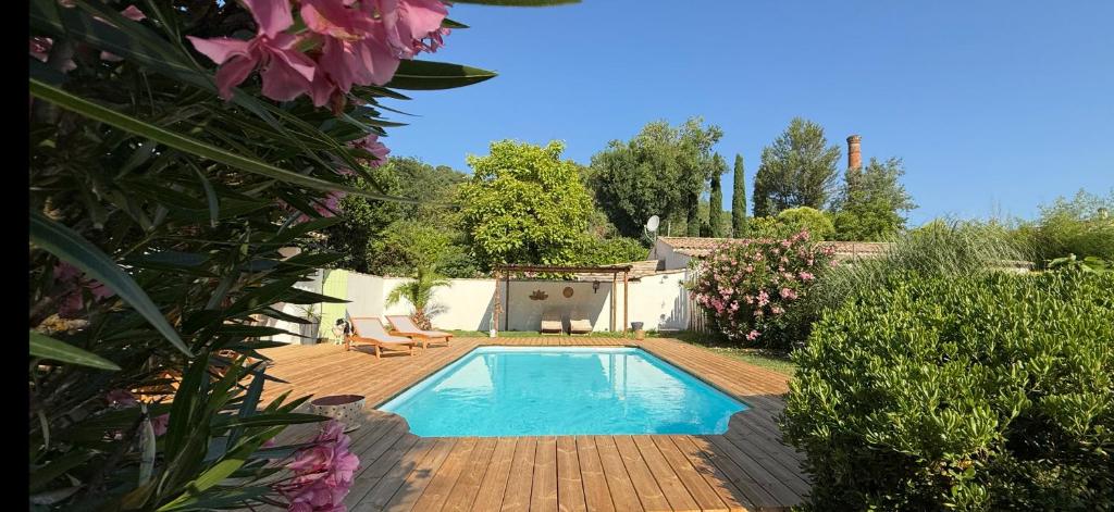 - une piscine dans un jardin avec 2 chaises et des fleurs dans l'établissement La Belle Rivière, à Salernes