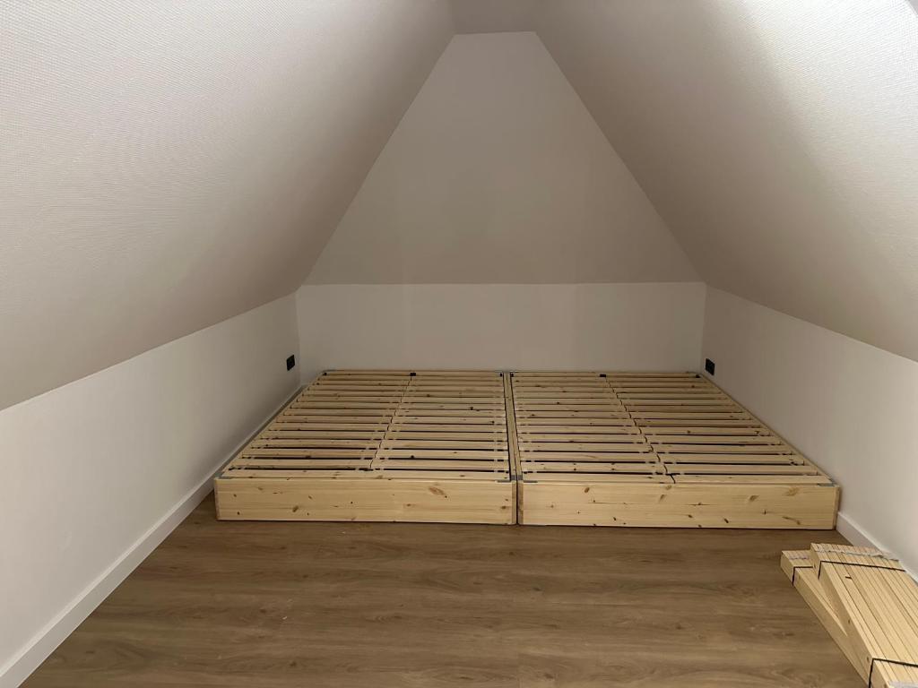 an attic room with a bed and wooden floors at Wohnen im alten Standesamt High 5 in Pasewalk