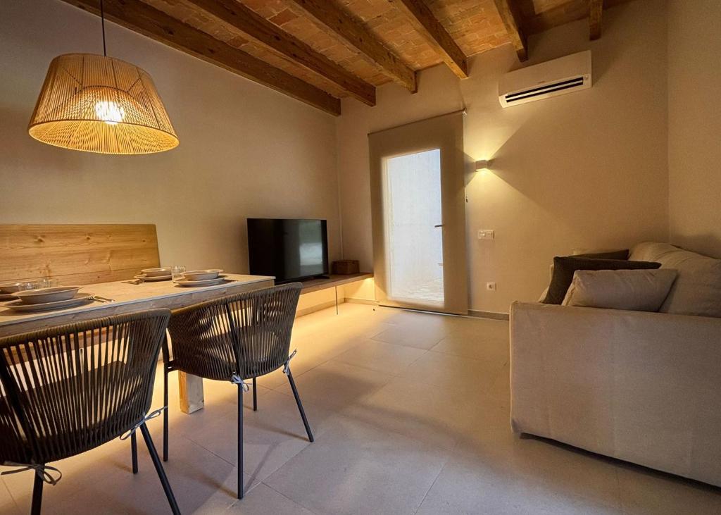 a living room with a table and chairs and a television at La Plana allotjament rural in Aviá
