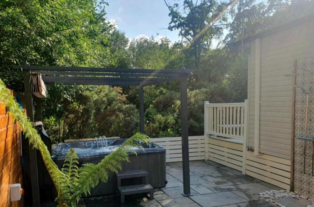 a hot tub under a pergola on a patio at The Treehouse Northumberland in Swarland