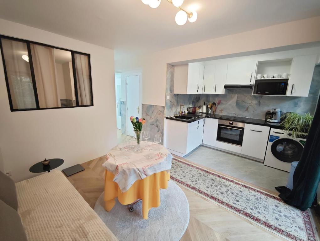 un salon avec une table et une cuisine dans l'établissement 2 min From Arc de Triomphe Elegant Apartment for 4, à Paris