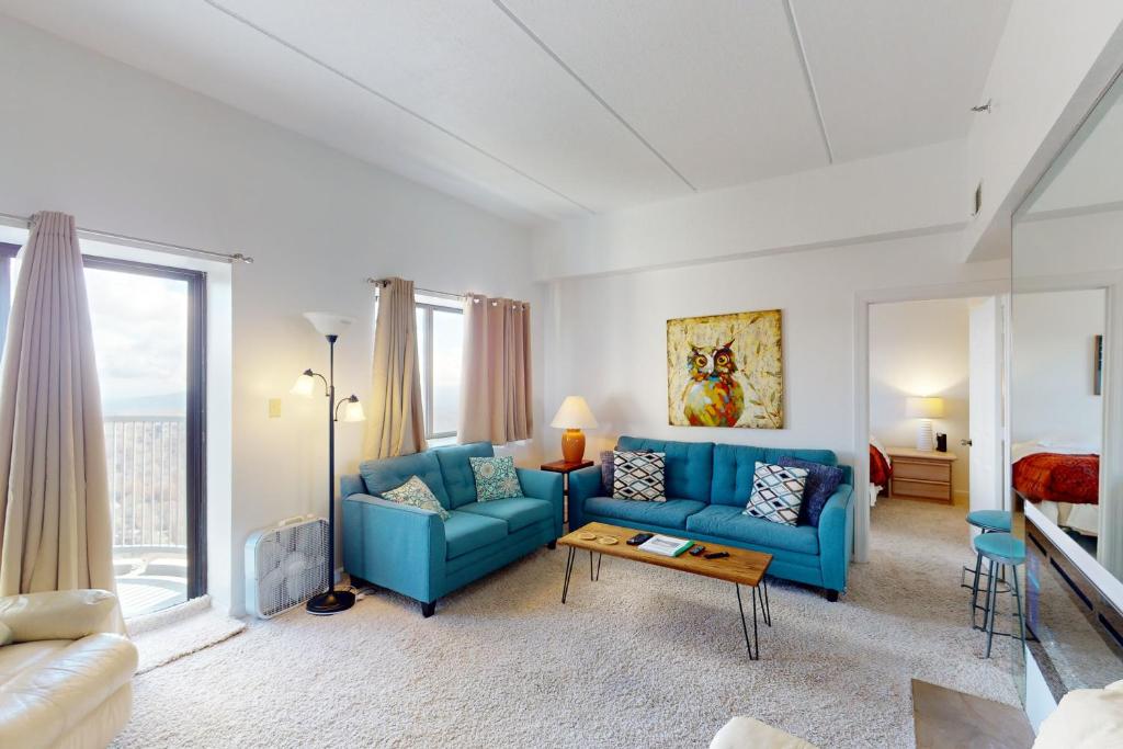 a living room with a blue couch and a table at Citadel 3626 in Sugar Mountain