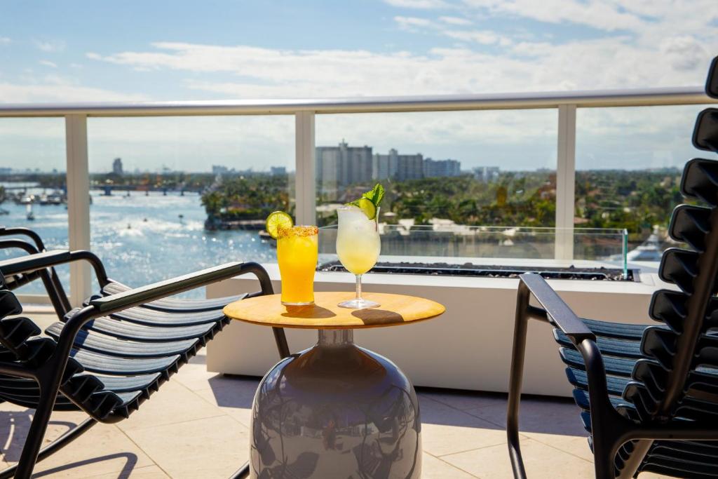 a table with two drinks on top of a balcony at The Kimpton Shorebreak Fort Lauderdale Beach Resort in Fort Lauderdale