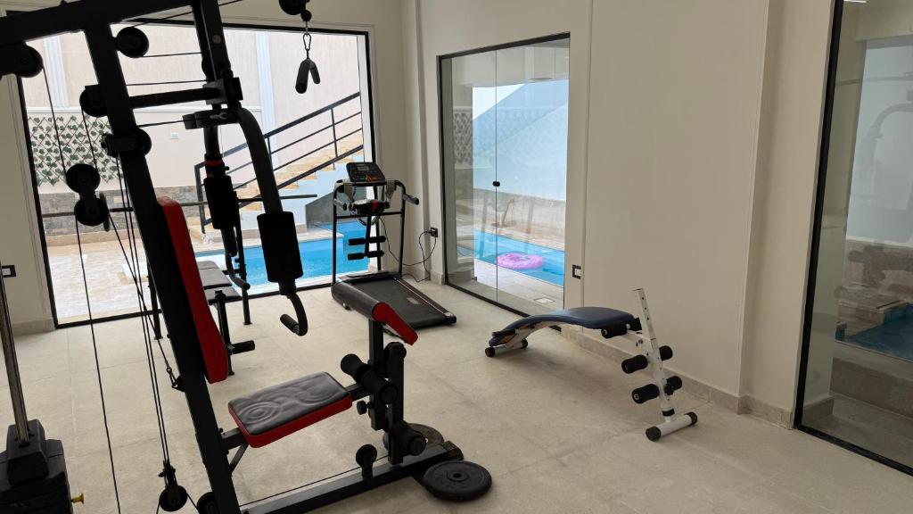 a gym with cardio equipment and a treadmill at Villa from Al Essam Development with private pool, jacuzzi and home cinema المجلس من ال عصام للتطوير مع المسبح والجاكوزي الخاص والهوم سينما in 6th Of October