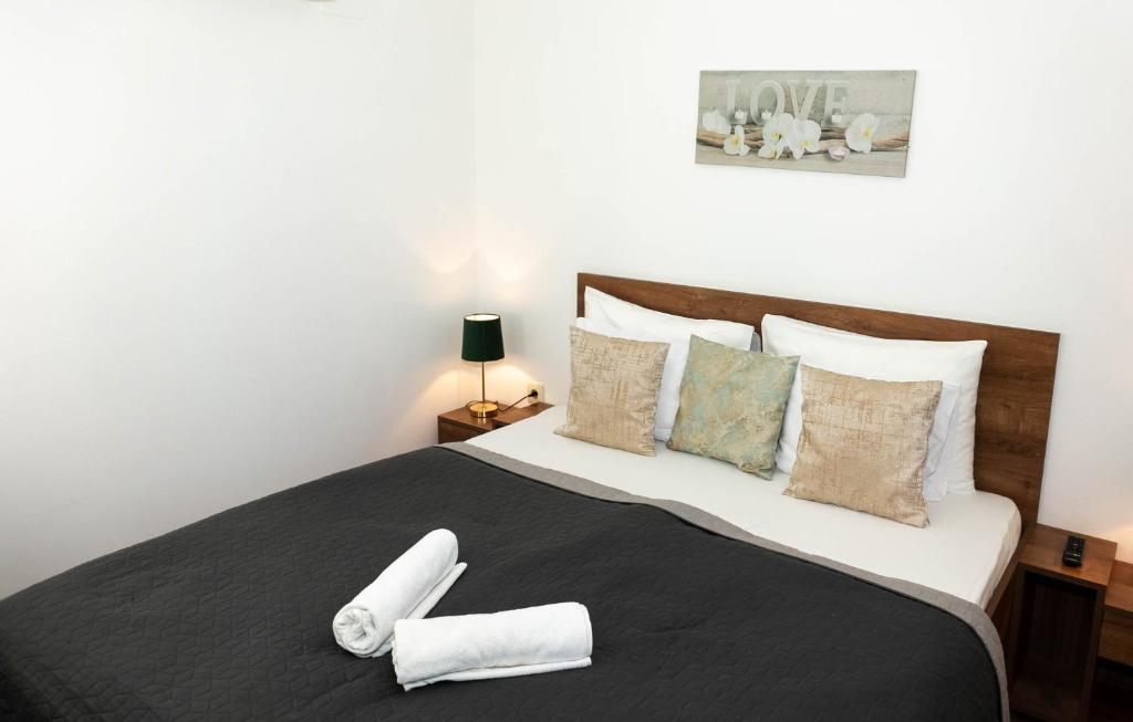 a bedroom with a large bed with two towels on it at Boró Apartman in Tiszafüred
