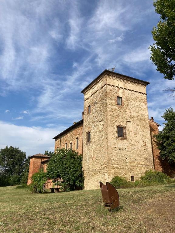 a large brick building in the middle of a field at La Torre Masana in Vigostano