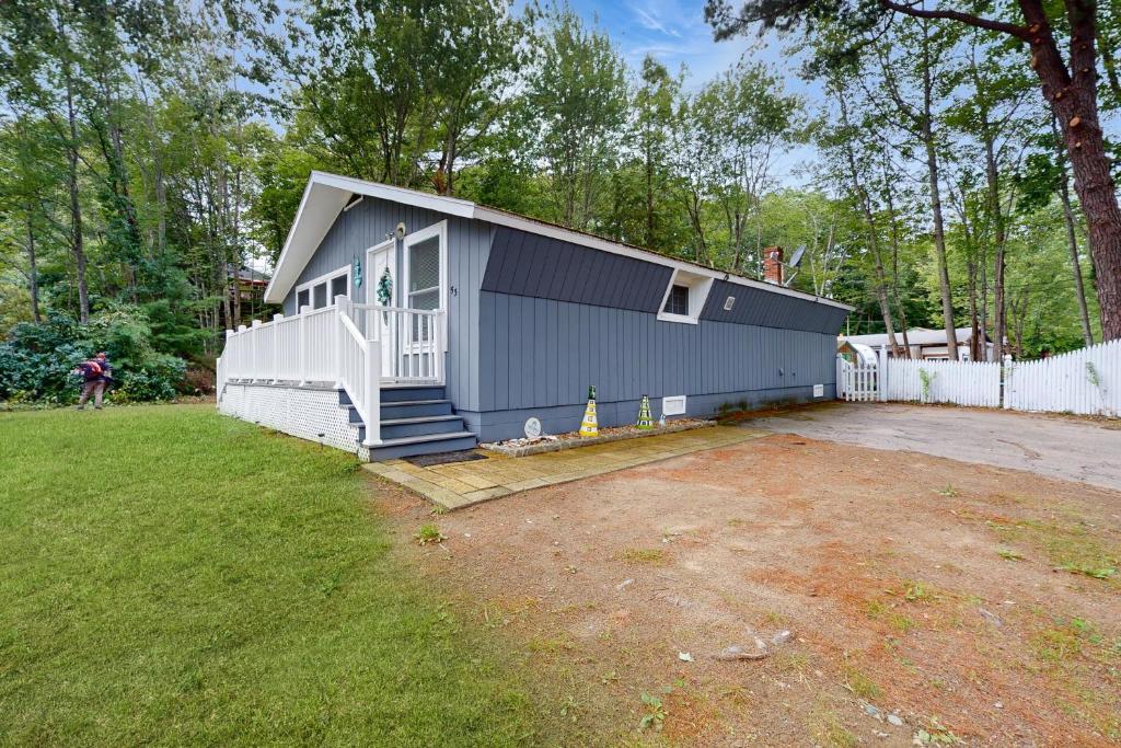 a blue building with a porch and a yard at Old Orchard Beach House in Old Orchard Beach