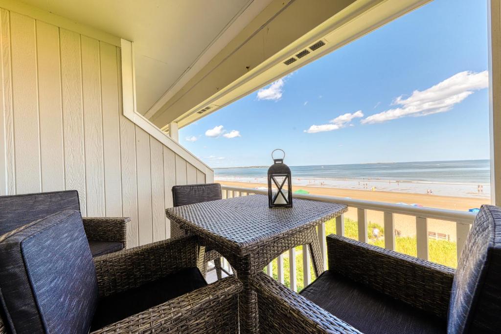 a table and chairs on a balcony with a view of the beach at Scouten Beachfront in Old Orchard Beach