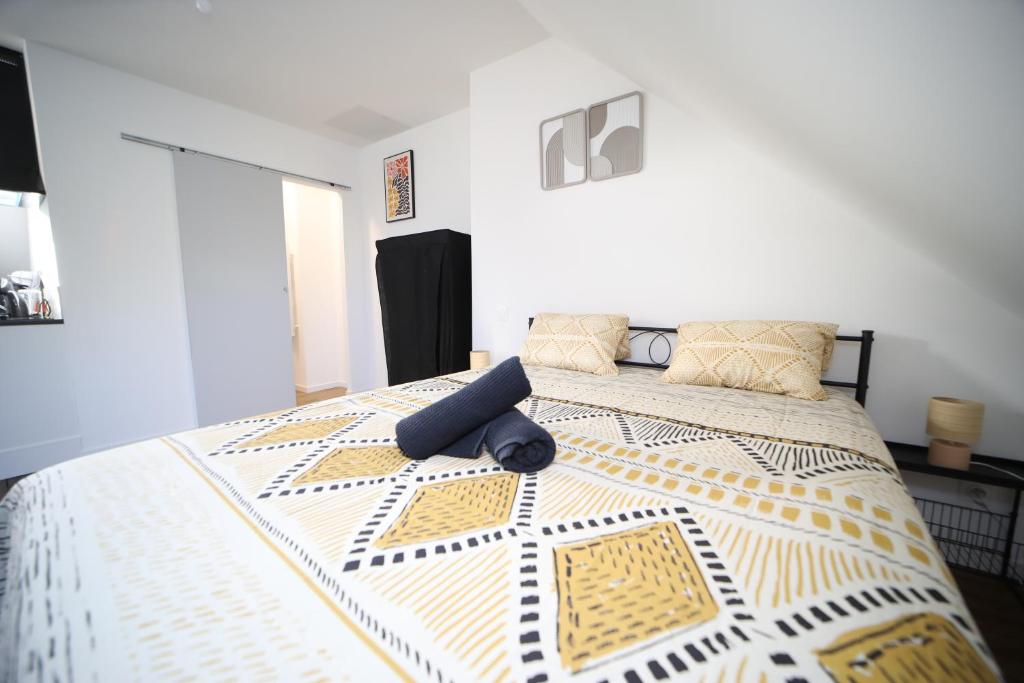 a bedroom with a large bed with a yellow and white comforter at Eden I, L'élégant! Seul , en couple ou en famille in Cambrai