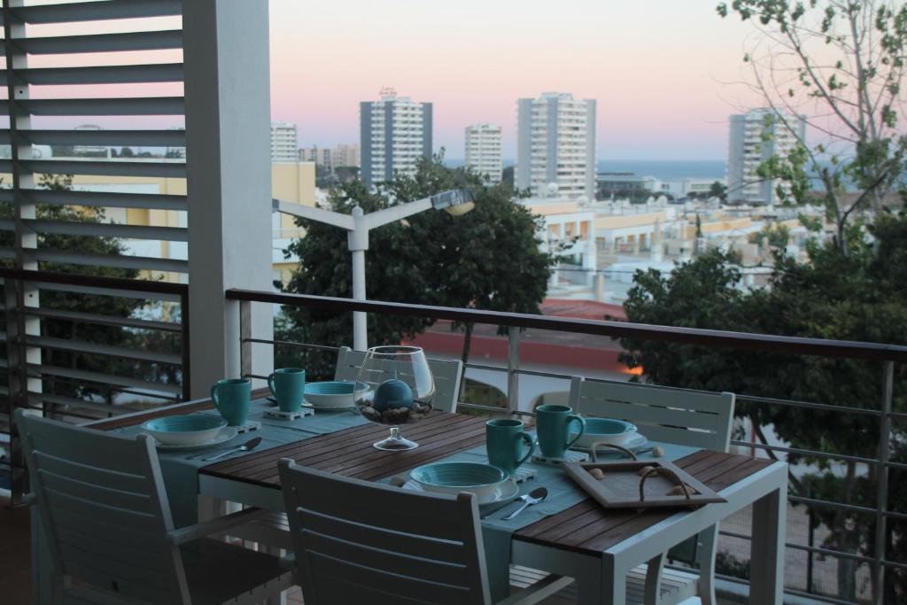 - une table sur un balcon avec vue sur la ville dans l'établissement Apartamentos Mar de Alvor, à Alvor