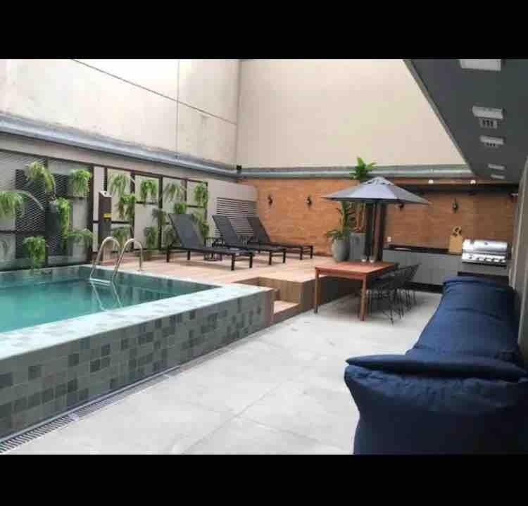 a large pool with a table and a bench and a table sidx sidx at RioDowntown Hub by RNC Flats in Rio de Janeiro
