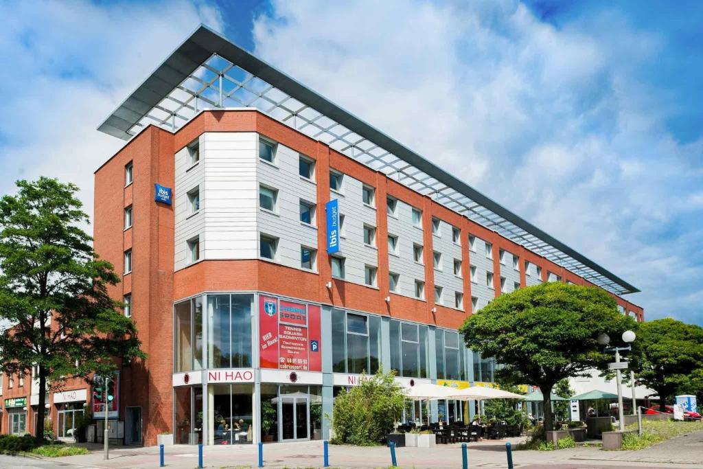 un grand bâtiment en brique rouge avec un panneau. dans l'établissement Ibis budget Hamburg City Ost, à Hambourg