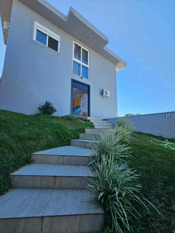 弗洛里亚诺波利斯MEG House Hostel的前面有楼梯的白色房子