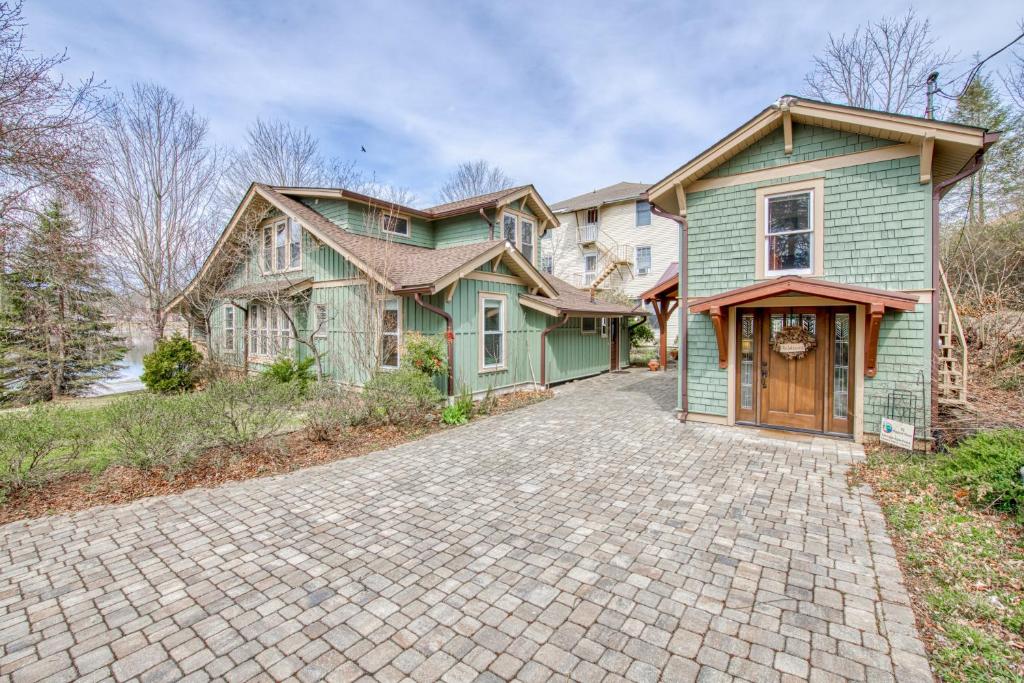 a large green house with a brick driveway at A Beautiful Carriage in Lake Junaluska