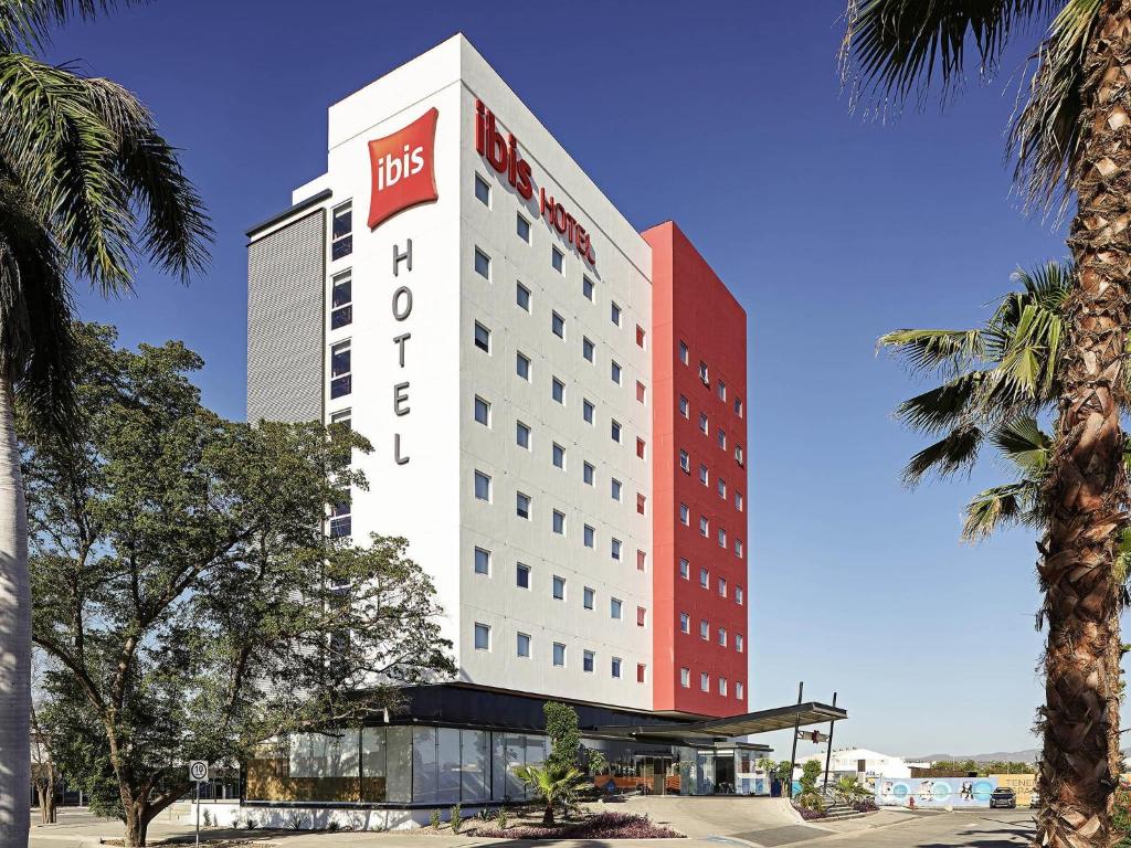 a hotel with a red and white building at Ibis Culiacan in Culiacán