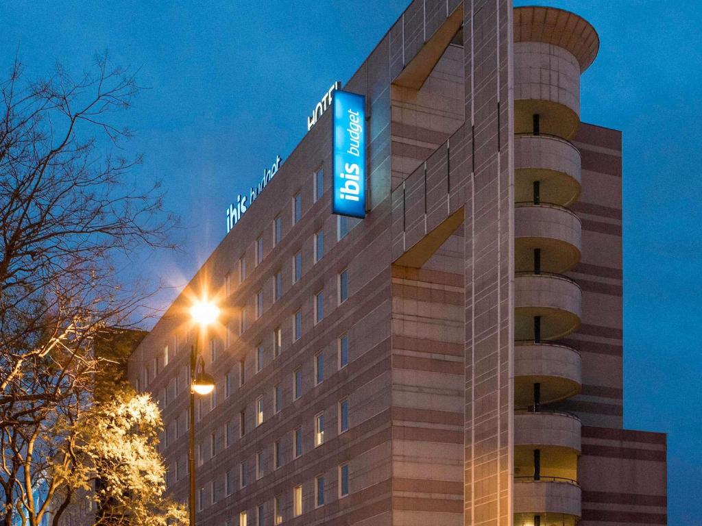 a hotel with a sign on the side of a building at ibis budget Paris Porte De Montmartre in Paris