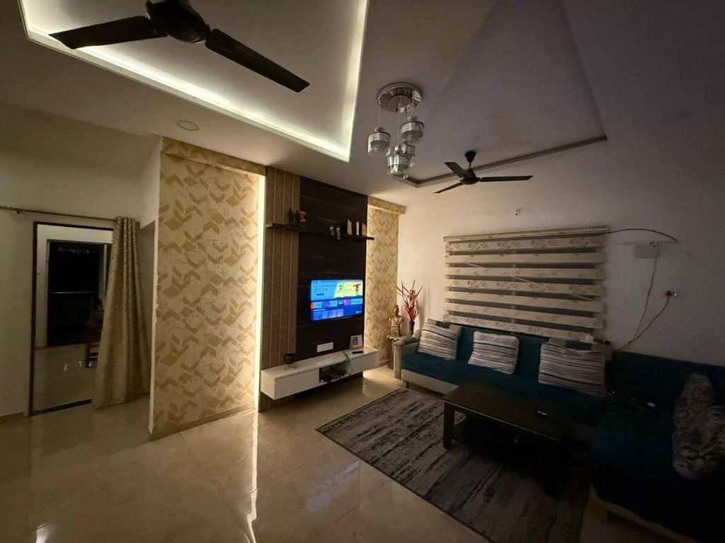 een woonkamer met een bank en een flatscreen-tv bij 2BHK Galaxy Height Shree Nagar Nagpur in Nagpur