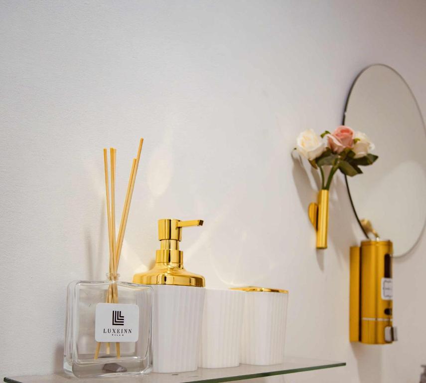 une étagère avec un flacon de parfum et un miroir dans l'établissement LuxeInn, à Trece Martires