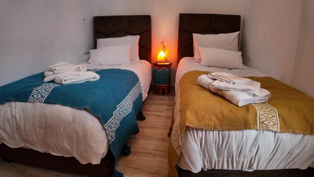 two beds sitting next to each other in a room at La casa de Oasis in Essaouira