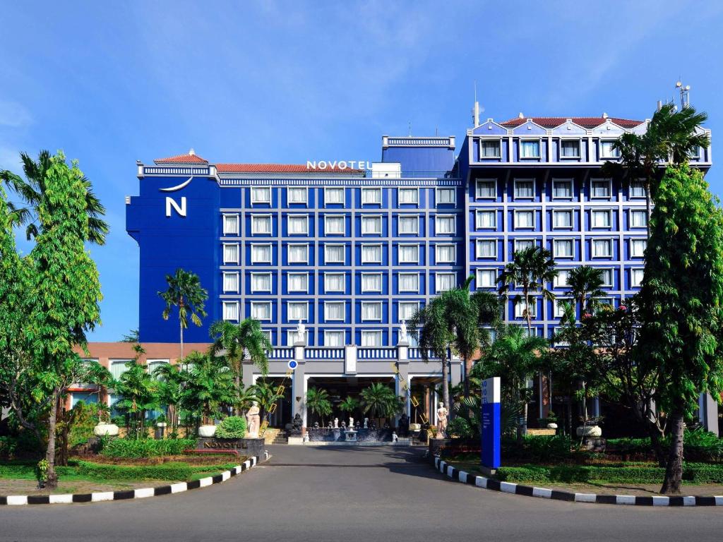a large hotel with a blue and white building at Novotel Solo in Solo