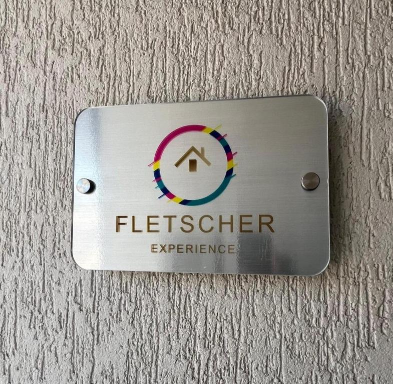 a sign on a wall that readsfletcher experience at Comfort and convenience for your family stay in Ibagué