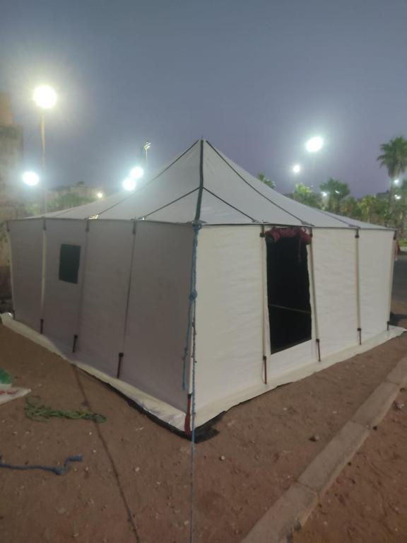 a large white tent in the dirt at night at Camp azawan hananich 