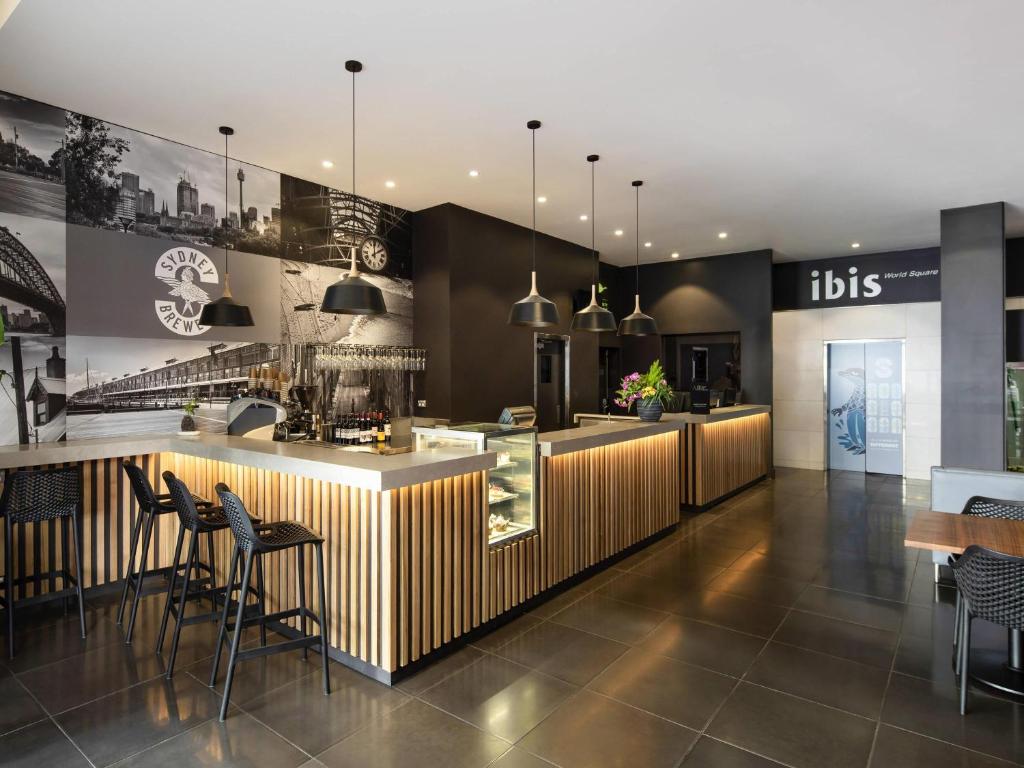 un restaurant avec un bar avec des chaises et des tables dans l'établissement ibis Sydney World Square, à Sydney