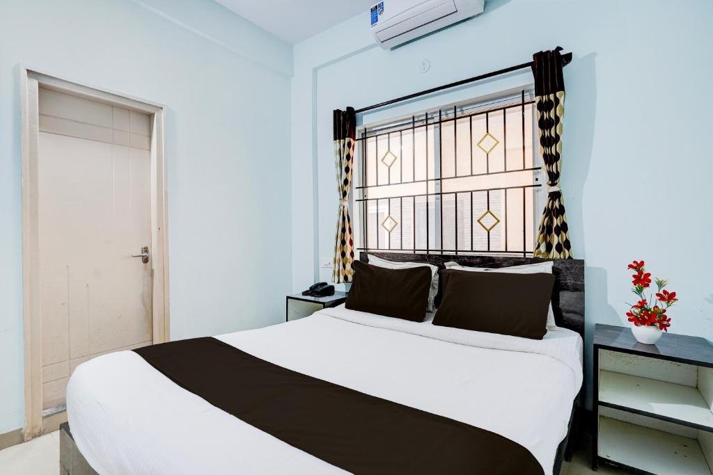 a bedroom with a large white bed and a window at Super Collection O Uttarahalli in Bengaluru