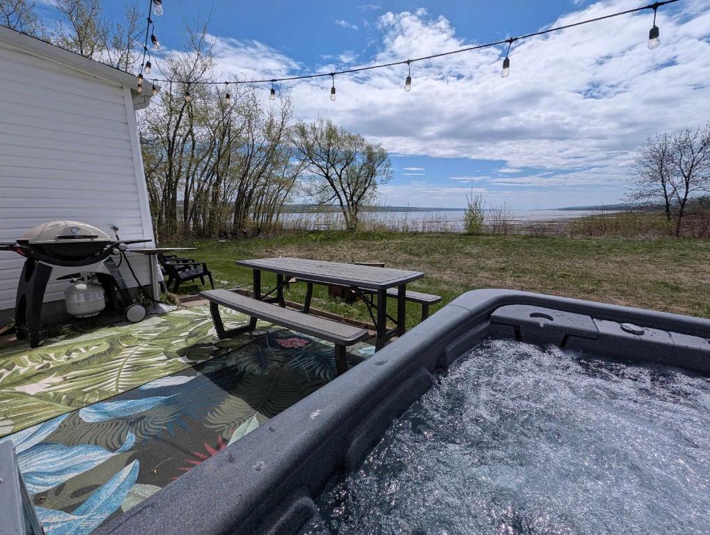 a picnic table and a picnic table in a pool at Condo 1 - Waterfront with SPA Fireplace & Barbecue in Sainte-Anne-de-Beaupré