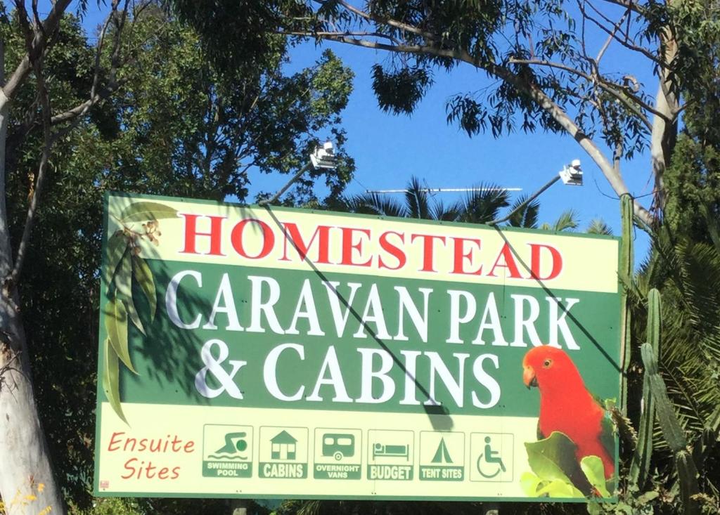 un panneau indiquant un parc de dinosaures et une captivité dans l'établissement Homestead Caravan Park, à Nanango