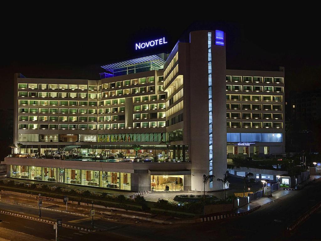 a hotel with a sign on top of it at night at Novotel Visakhapatnam Varun Beach in Visakhapatnam