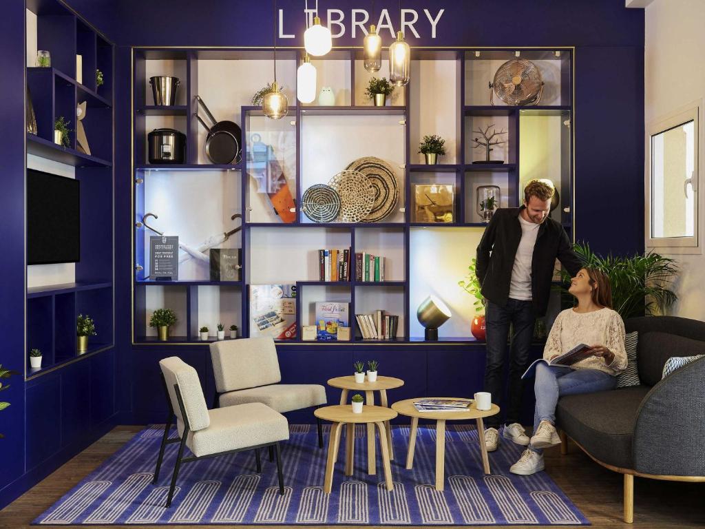 a man and a woman standing in a living room at Aparthotel Adagio Monaco Palais Joséphine in Beausoleil