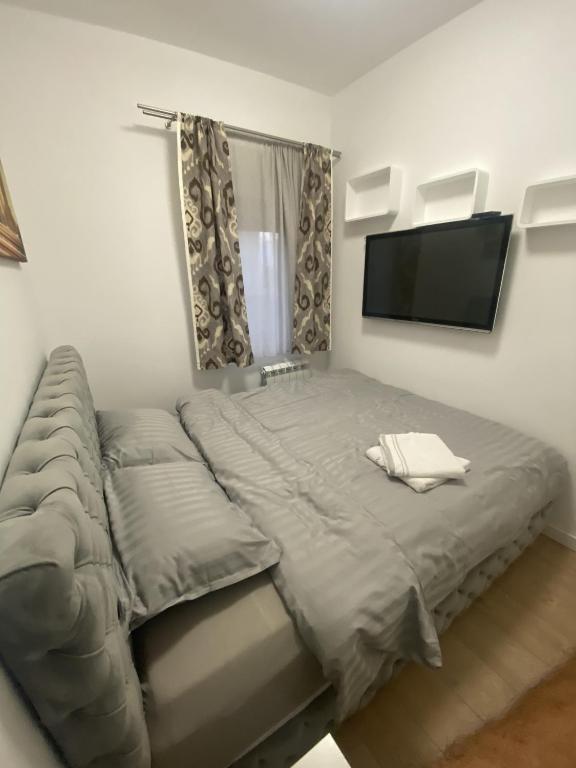 a bedroom with a bed and a flat screen tv at Apartman 601 in Surčin