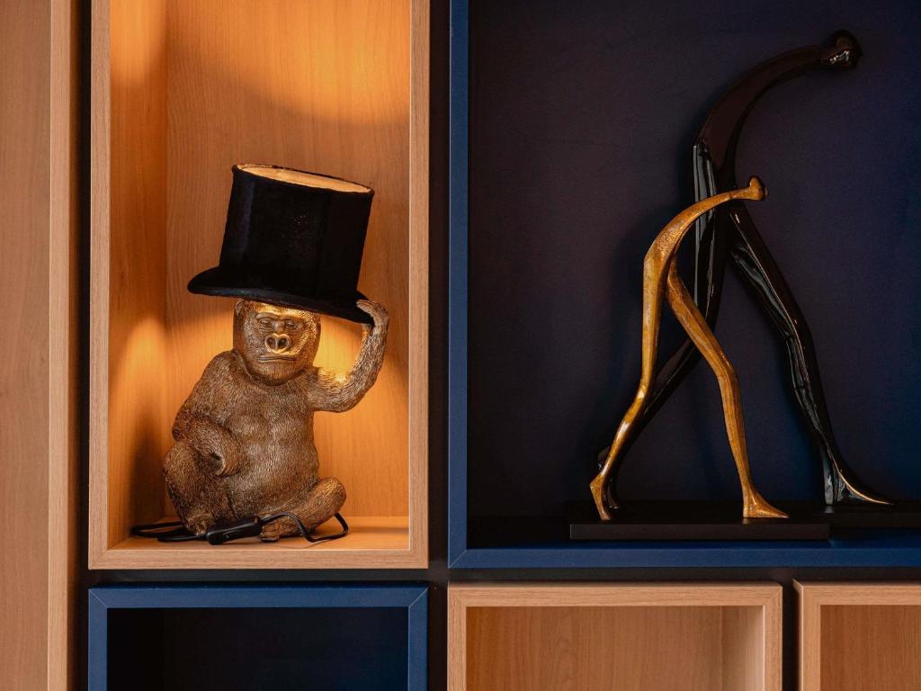 a toy monkey with a top hat in a cabinet at ibis Nancy Centre Stanislas in Nancy