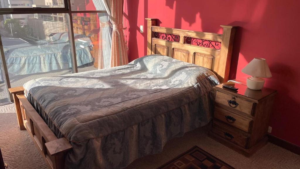 a bedroom with a bed and a table with a lamp at Muy cerca, a pasos de la Embajada de EEUU in La Paz