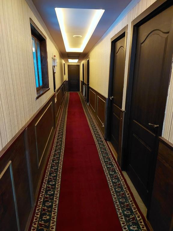 a long hallway with a red carpet and doors at Elit Hotel in Mingachevir
