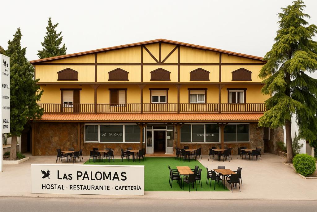 a building with tables and chairs in front of it at HOSTAL LAS PALOMAS in Lucena