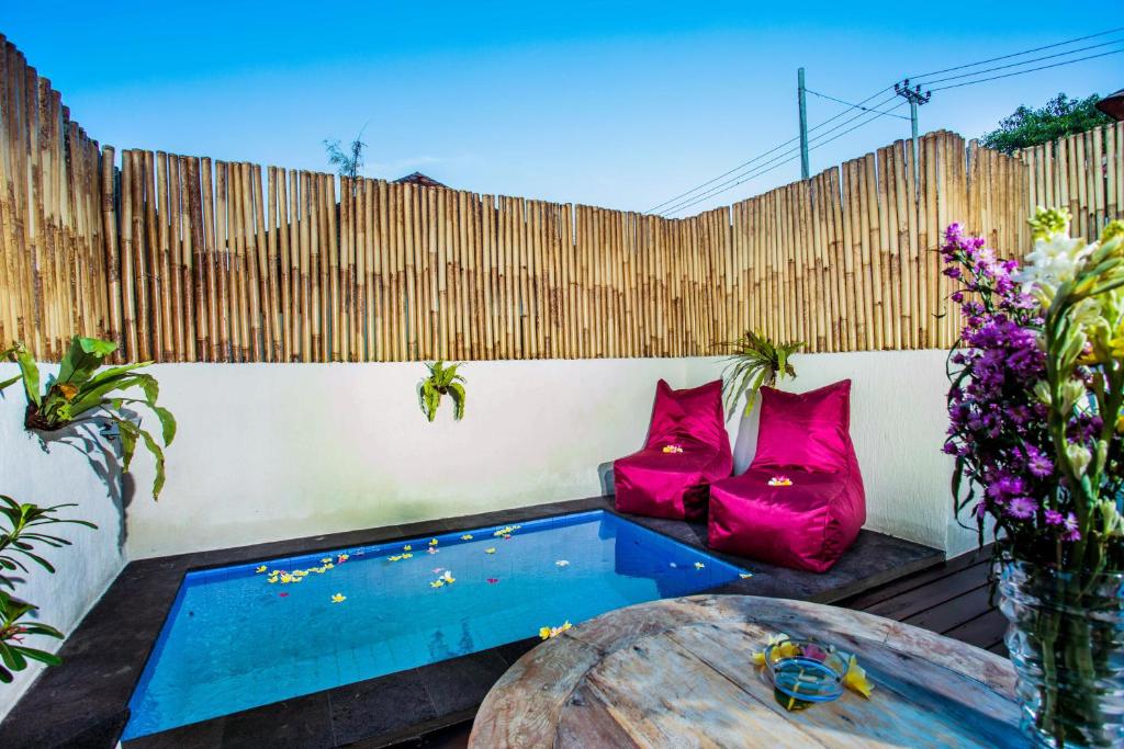 un patio trasero con piscina, mesa y valla en Svaha Private Villas Ceningan, en Nusa Lembongan