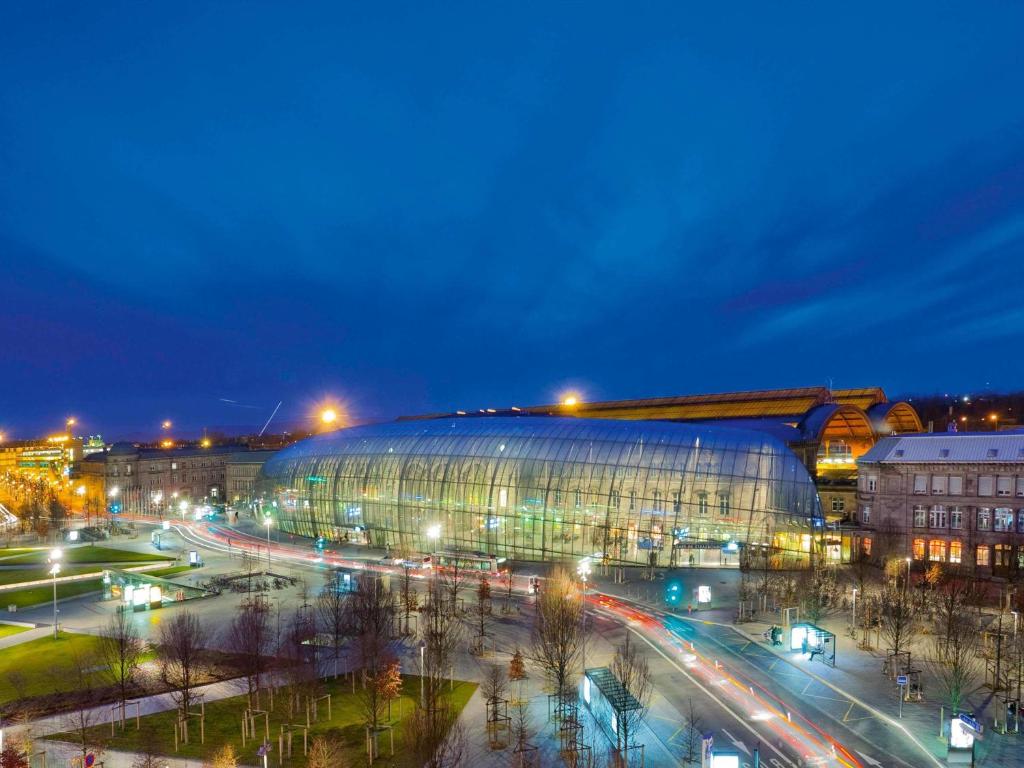 a large building in a city at night at Mercure Strasbourg Centre Gare in Strasbourg