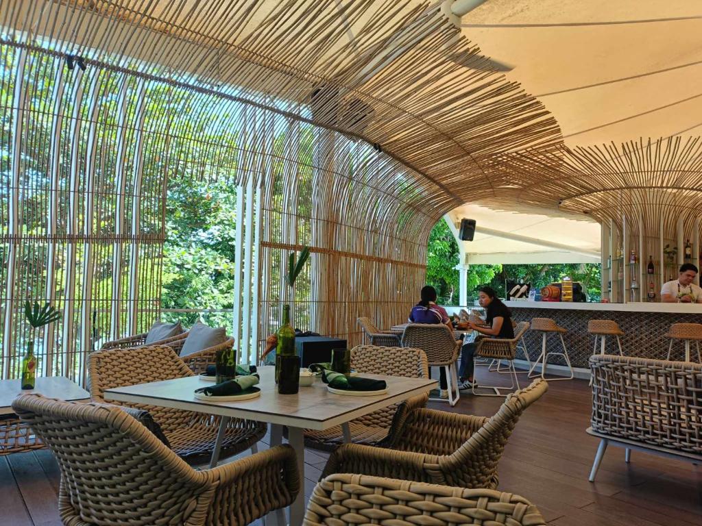 a restaurant with a wooden ceiling and chairs and tables at El Paseo Tambuli in Maribago
