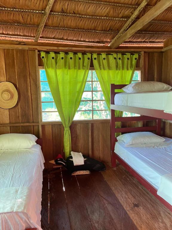 a bedroom with two bunk beds and a window at Hostal Maguare-Reserva Indígena Maguare in Leticia
