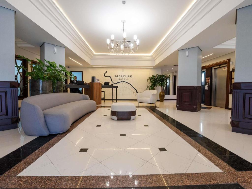 a living room with a couch and a table at Mercure Jaragua do Sul in Jaraguá do Sul