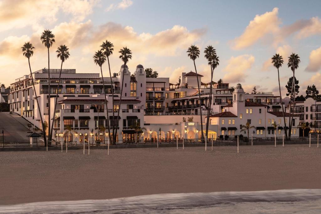 Un gran edificio blanco en la playa con palmeras. en La Bahia Hotel & Spa, en Santa Cruz