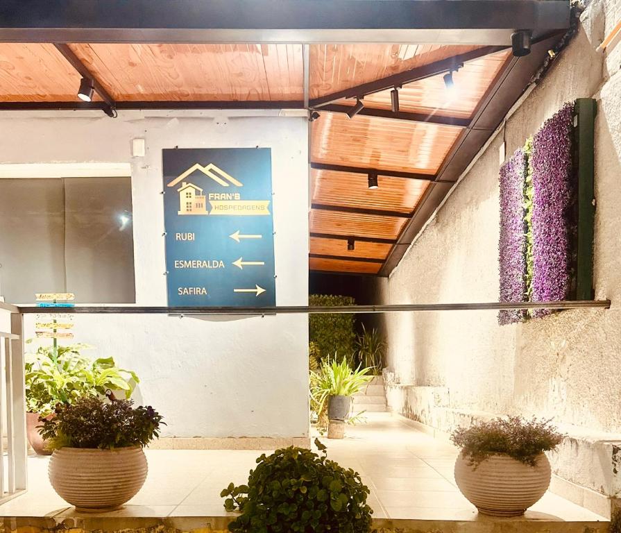 a sign on the side of a building with plants at FRAN's - HOSPEDAGENS in Lagoa Santa