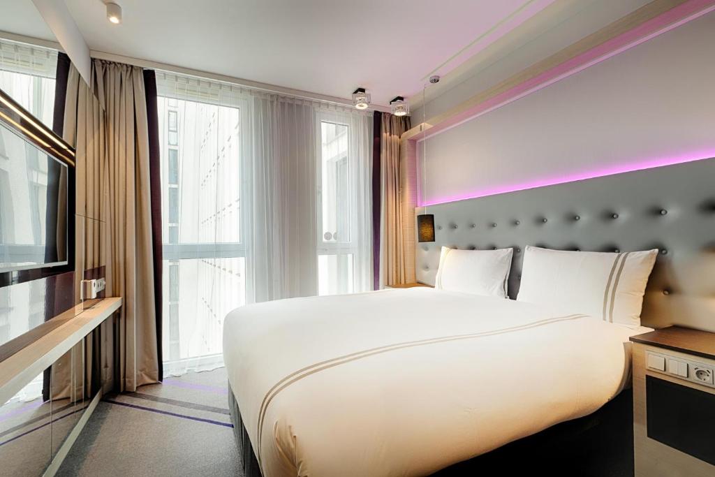 ベルリンにあるPremier Inn Berlin Alexanderplatzの大きなベッドと大きな窓のある寝室