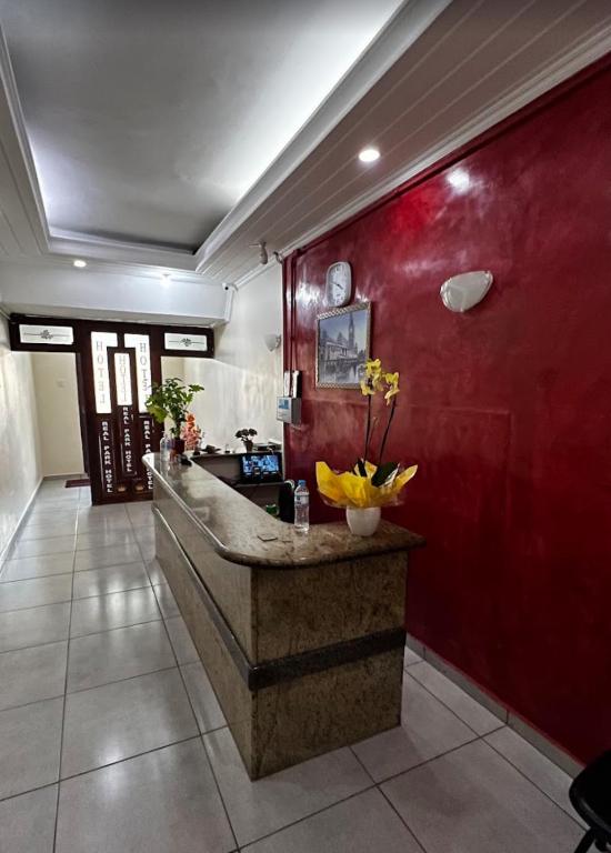 un vestíbulo con un mostrador con una pared roja en Real Park Hotel, en Osasco