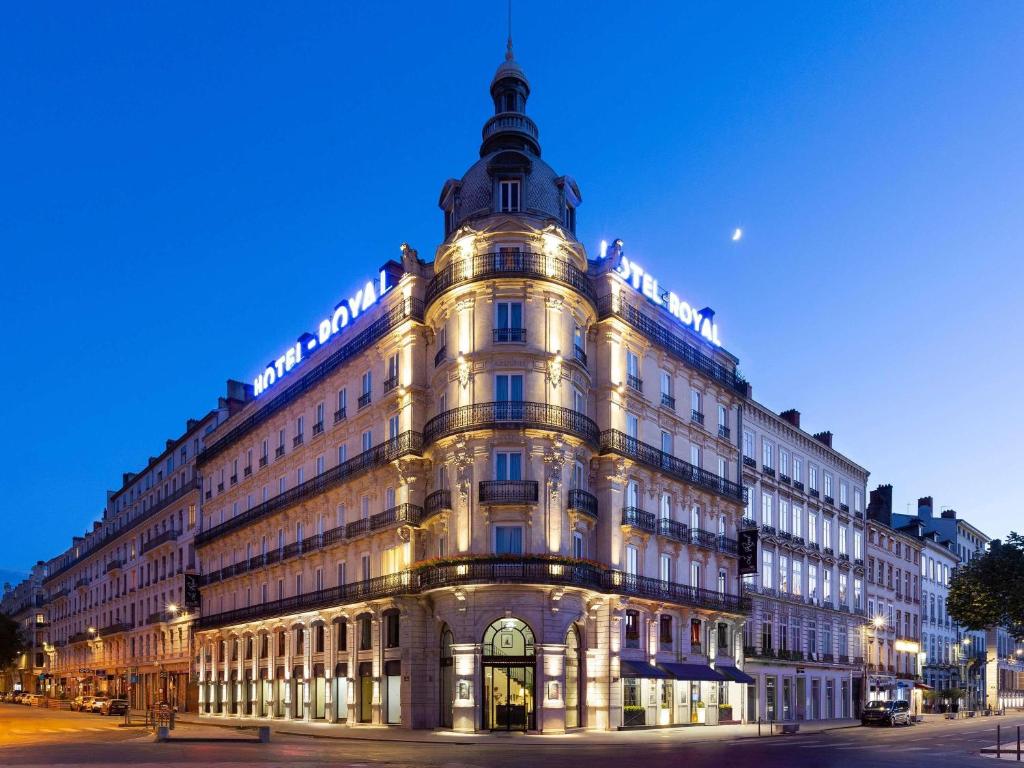 a large building with a clock on the side of it at Le Royal Hotel Lyon - MGallery Collection in Lyon