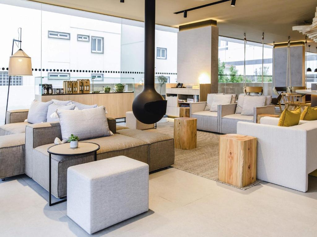 a living room with couches and chairs and tables at Mercure Fátima in Fátima